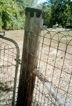 The gate is made from the same netting fencing material that surrounds the cemtery.